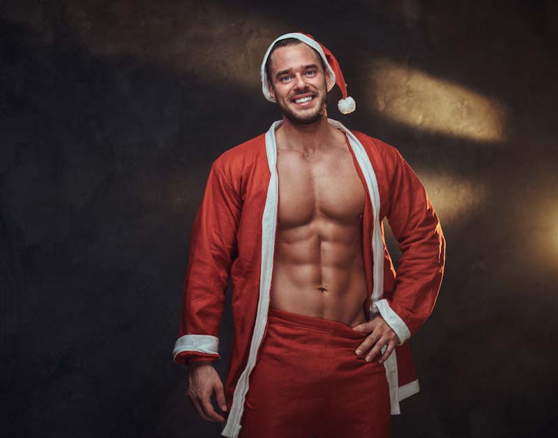 A fit personal trainer poses in holiday cheer. Learn tips for managing your fitness clients over the holidays at EliteTrainr.com.