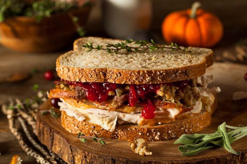 This file photo shows a turkey, stuffing, and cranberry sandwich on whole wheat bread - a healthy meal utilizing holiday leftovers. For more holiday food nutrition ideas read more from EliteTrainr.com.