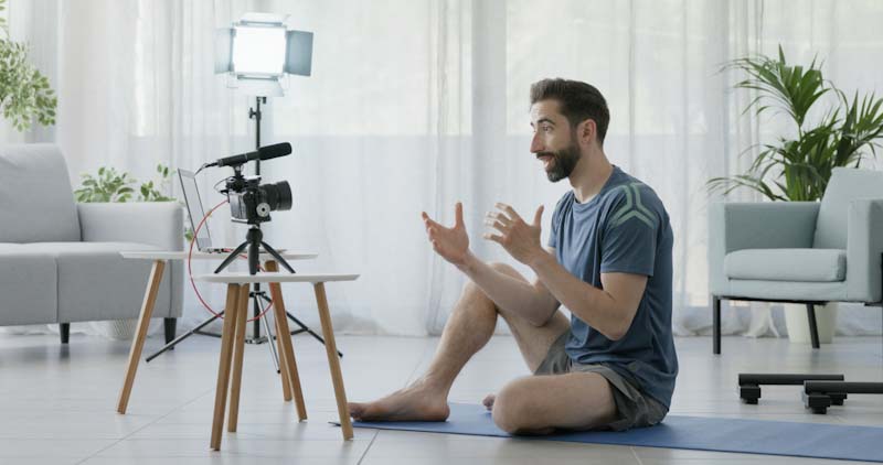 A personal trainer films special holiday fitness motivational videos in his home.