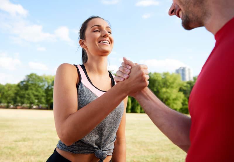 A personal trainer and client shake hands. Spring Fitness Program Creation To Supercharge Your Client's Motivation is easy with EliteTrainr.com.