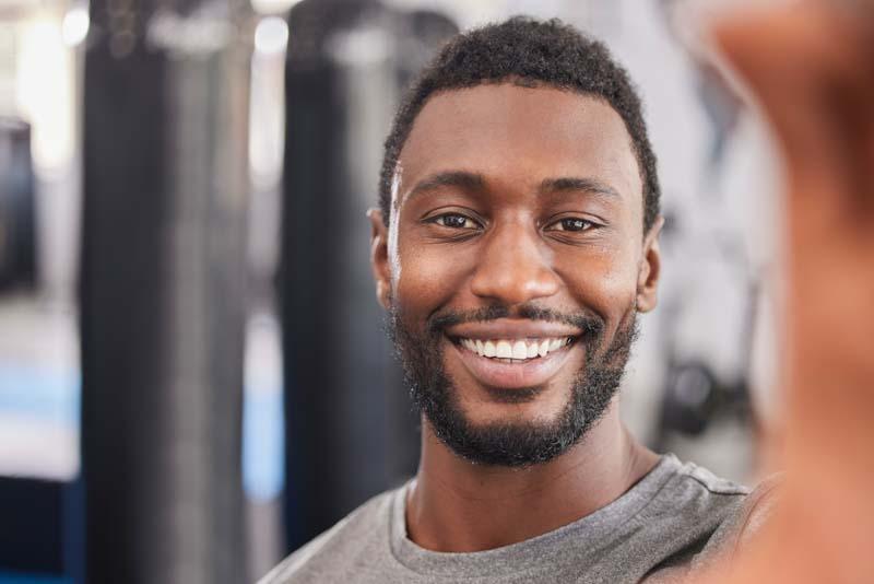 A personal trainer takes a happy selfie after setting up his fitness client management with Elite Trainr. Learn more at EliteTrainr.com.