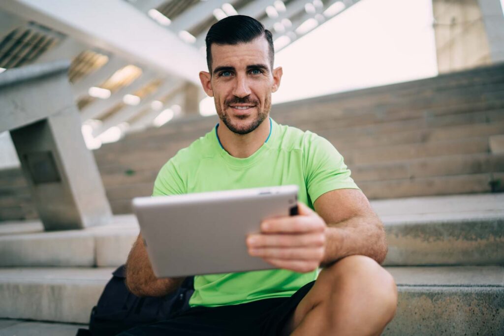 A personal trainer holding a tablet.